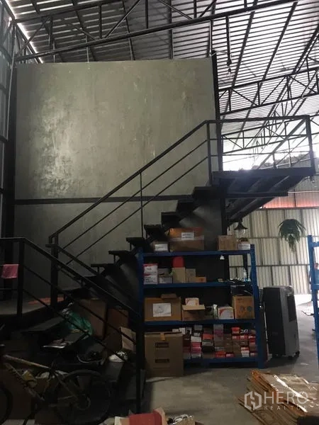 Warehouse for rent in Bang Kapi, Bangkok - Steel staircase to mezzanine office with shelving and storage under a high roof.