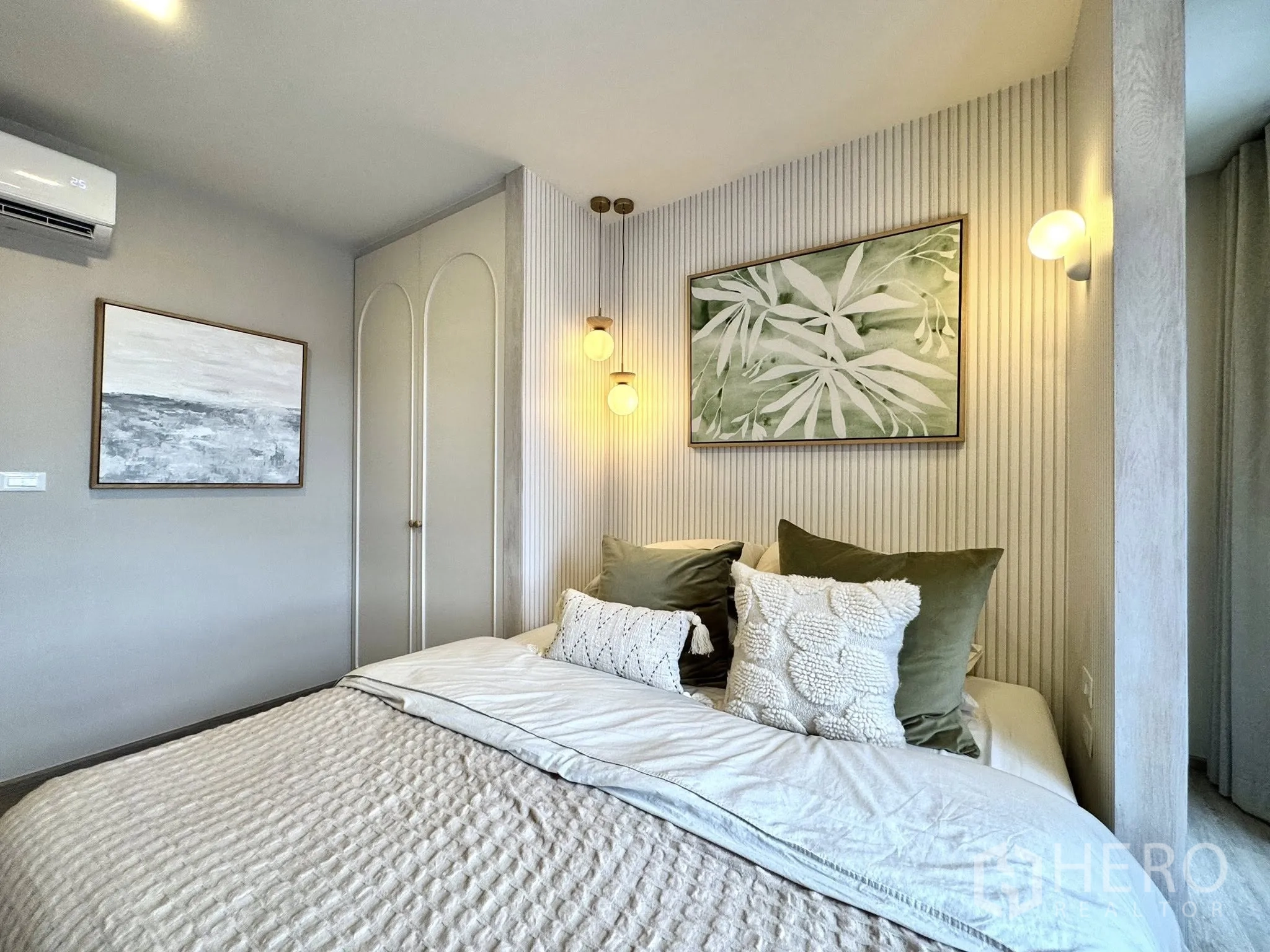 公寓 for rent in Watthana, Bangkok - 次卧另一角度，展示软装床品、壁灯、装饰画与空调。