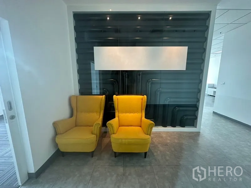 办公空间 出租在Chatuchak, Bangkok - 接待角落，两把黄色扶手椅与特色背景墙