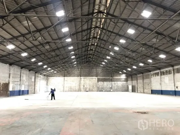 货栈 出租在Pak Kret, Nonthaburi - Pak Kret, Nonthaburi 仓库内部，钢结构高挑屋顶，天窗与平整混凝土地面。