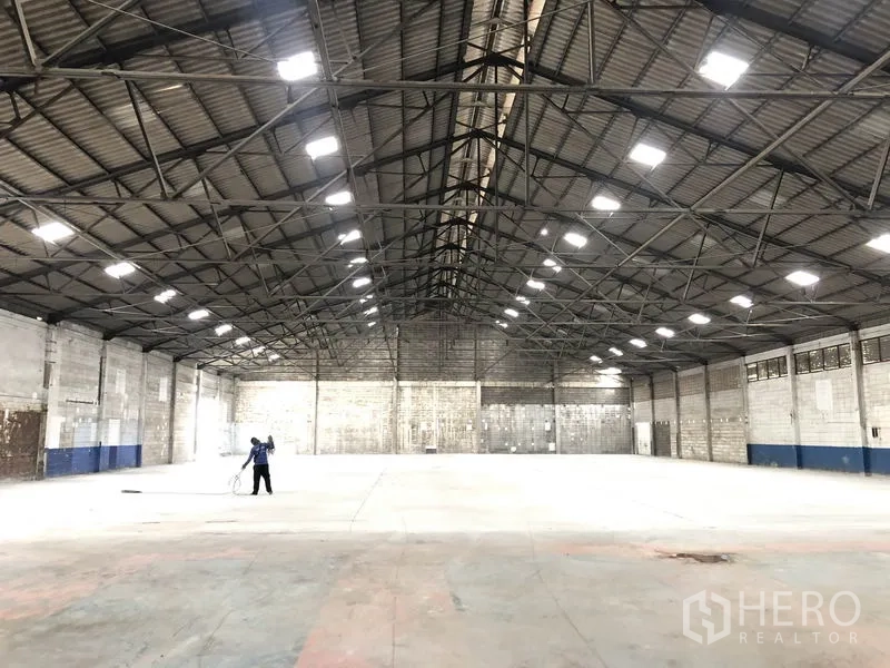 货栈 出租在Pak Kret, Nonthaburi - Pak Kret, Nonthaburi 仓库内部，钢结构高挑屋顶，天窗与平整混凝土地面。