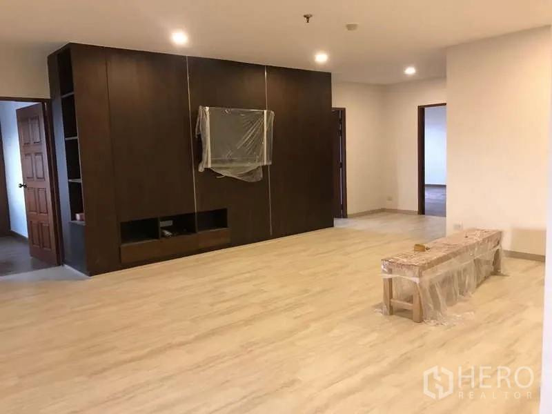 คอนโด ขายในWatthana, Bangkok - ห้องนั่งเล่นมีผนังทีวีไม้สีเข้มแบบเต็มผืนและพื้นโทนอ่อน