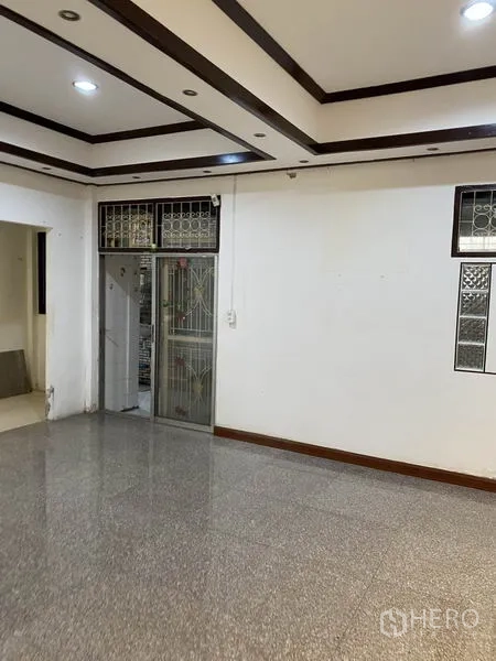 联排别墅 出租在Lat Phrao, Bangkok - 宽敞客厅，吊顶射灯与金属推拉门