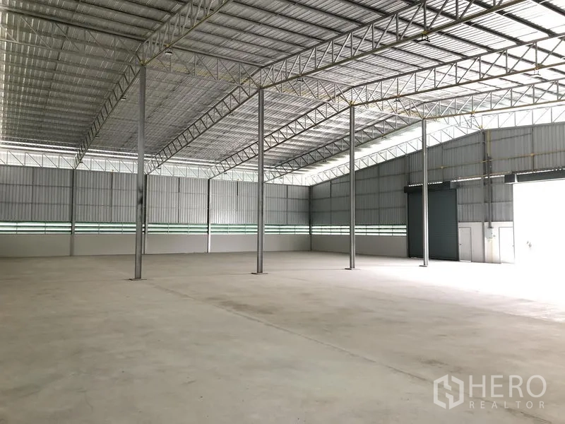 Warehouse for rent in Lat Lum Kaeo, Pathum Thani - Interior perspective of large warehouse with high ceiling and skylight strips.