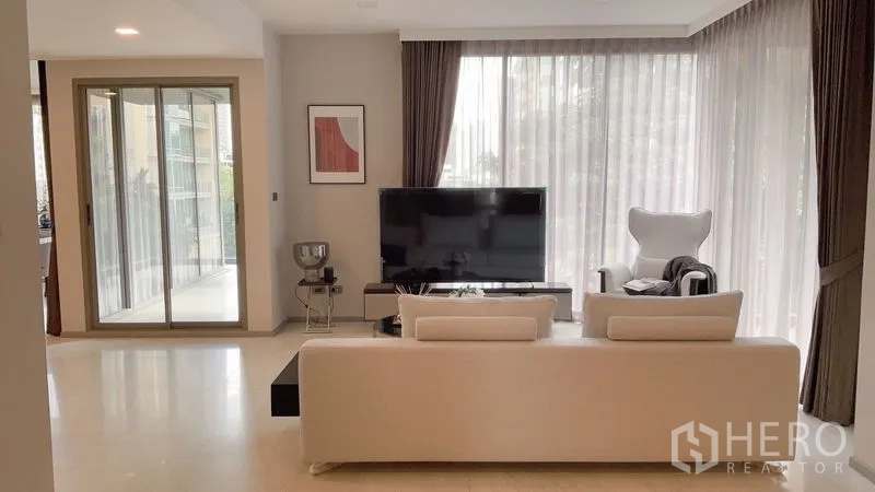 公寓 出租在Watthana, Bangkok - 客厅朝向电视与阳台移门，四周转角纱帘大窗。