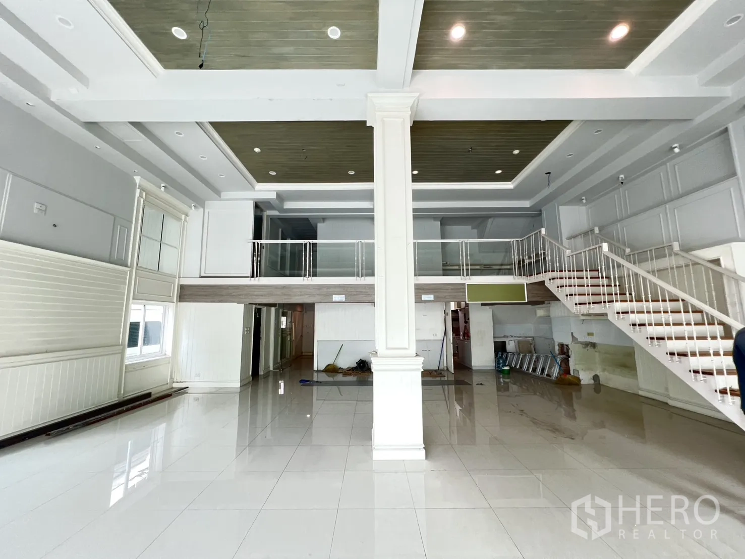 店屋 出租在Bang Rak, Bangkok - 店屋一层展厅挑高空间，亮面地砖，带夹层与楼梯。