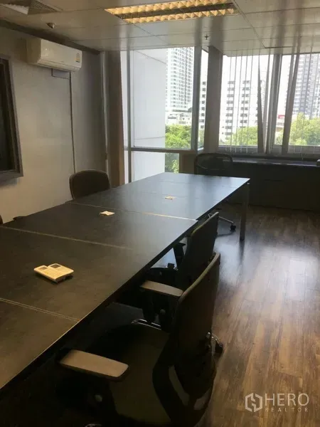 Office Space for rent in Khlong Toei, Bangkok - Boardroom with large windows offering city views and natural light over dark wood flooring.