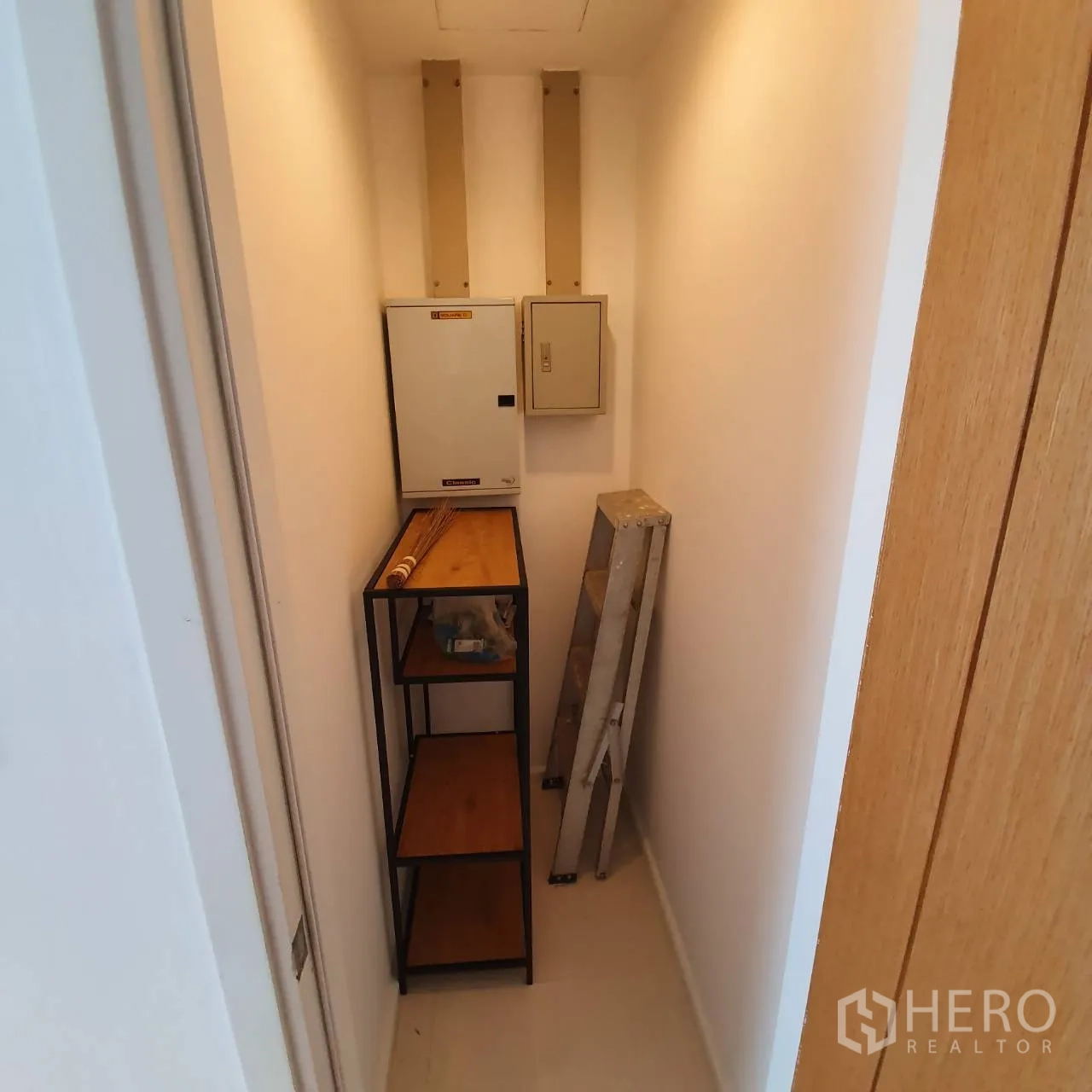 Condominium for rent in Watthana, Bangkok - Small storage room with metal shelves, electrical panels and a folding ladder.