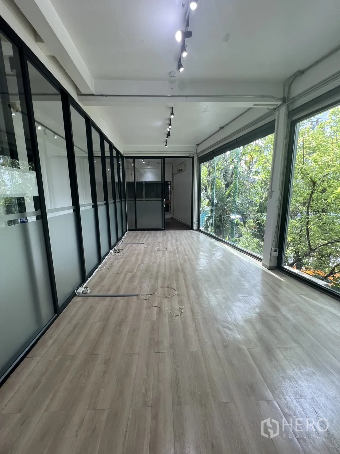 零售空间 出租在Watthana, Bangkok - 采光充足的展厅，落地窗临绿景，配磨砂玻璃墙。