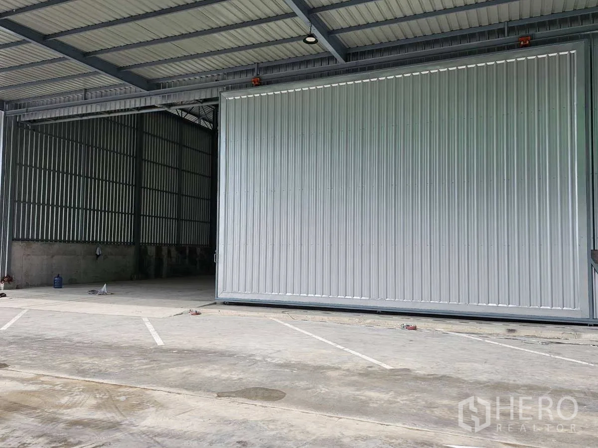 คลังสินค้า ให้เช่าในLam Luk Ka, Pathum Thani - ลานคอนกรีตกว้างมีช่องจอดรถ หน้าโกดังพร้อมประตูบานเลื่อนอุตสาหกรรม