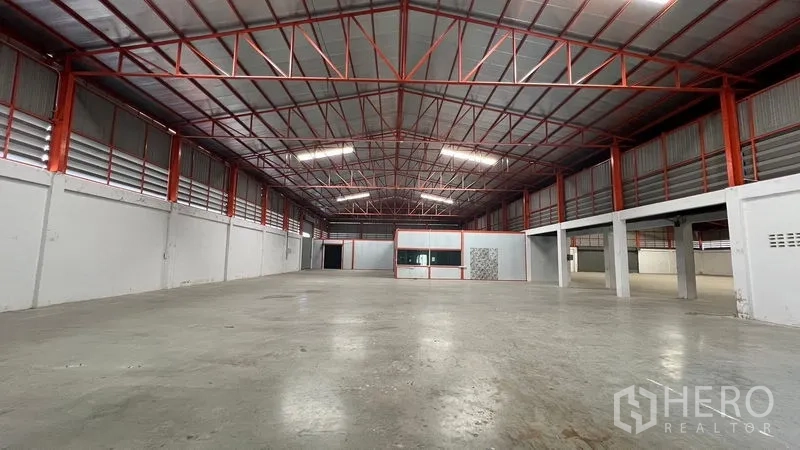 Warehouse for rent in Thanyaburi, Pathum Thani - Spacious warehouse hall with high red steel truss roof and smooth concrete floor.