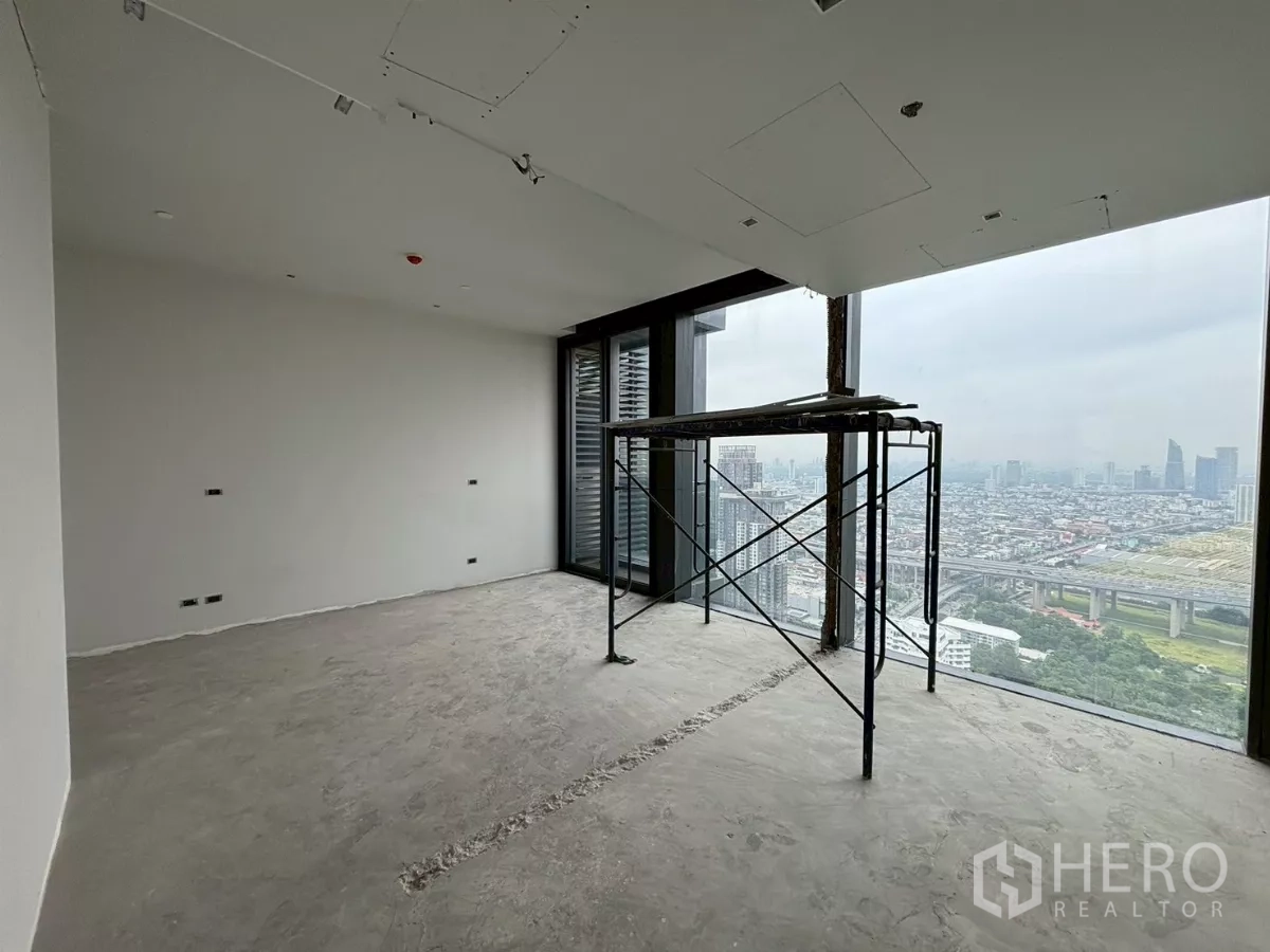 Condominium for sale in Bang Kho Laem, Bangkok - Unfinished bedroom with scaffold and expansive city views through full-height windows.