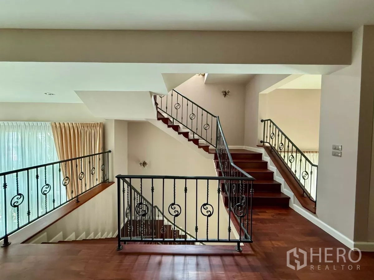 Townhouse for rent in Bang Kho Laem, Bangkok - Open stair hall with wrought-iron railings, wooden steps and tall windows