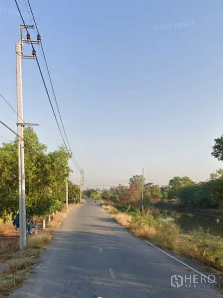 Land for sale in Bang Bua Thong, Nonthaburi - Quiet rural access road with electricity supply running alongside a canal.