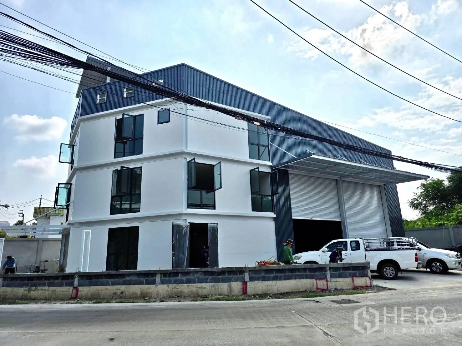 โกดัง for rent or sale in Mueang Nonthaburi, Nonthaburi - ด้านหน้าโกดังพร้อมประตูโหลดสินค้าขนาดใหญ่สองบานและลานจอดรถ