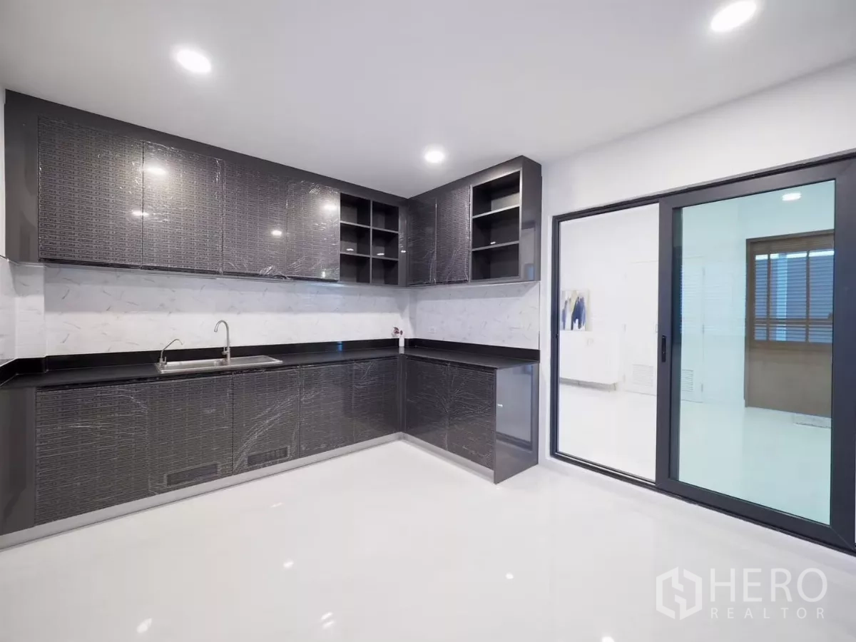 Detached House for rent in Bang Phli, Samut Prakan - Kitchen corner with ample cabinets, double sink and sliding glass door.