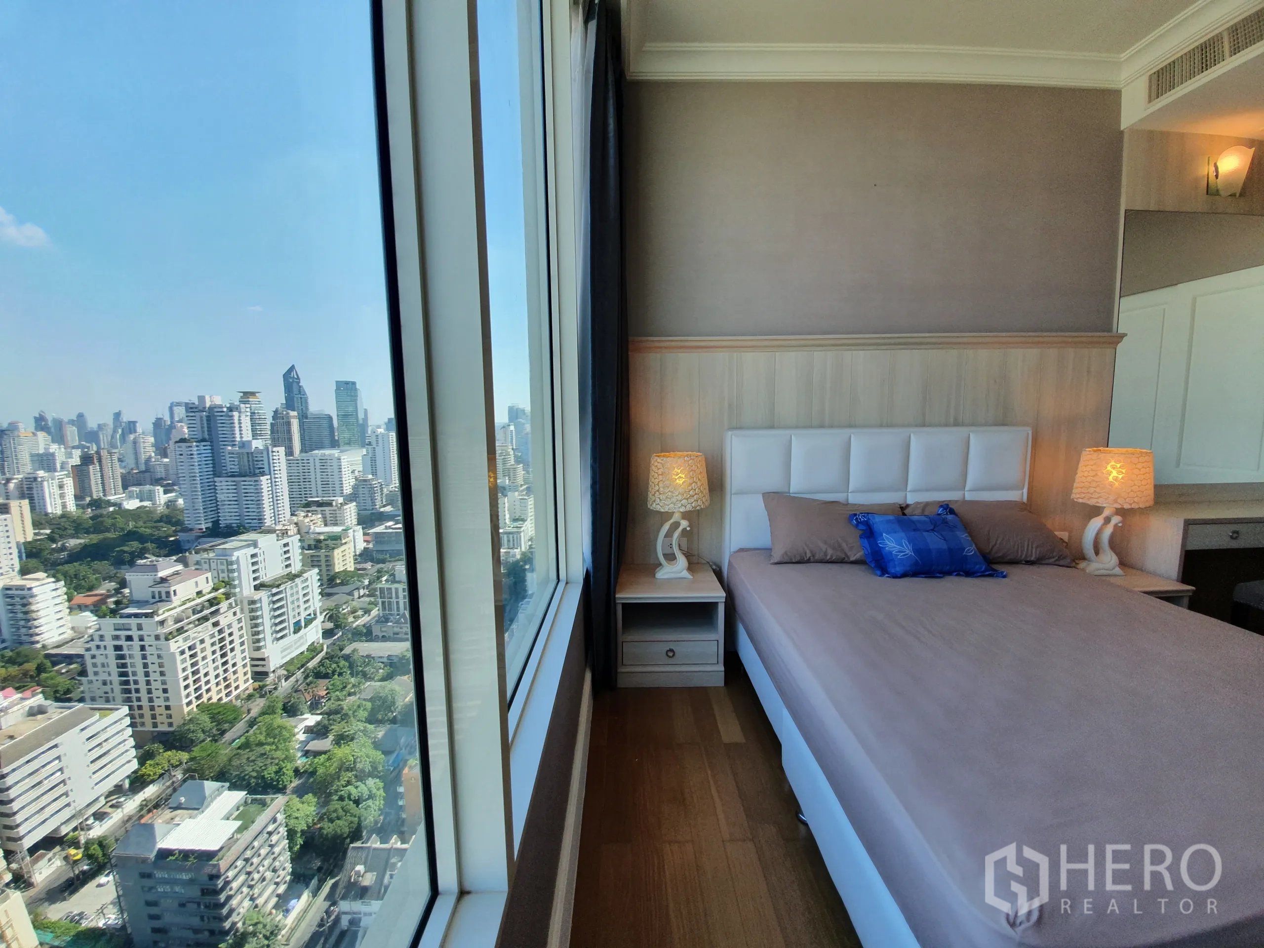 公寓 出租在Watthana, Bangkok - 第二卧室角度，可见床旁整面落地窗与全景天际线。