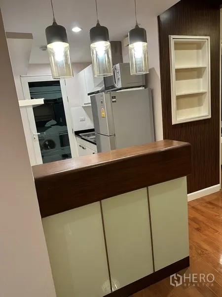 Condominium for rent in Watthana, Bangkok - Breakfast bar with pendant lights overlooking the kitchen and adjacent laundry area.