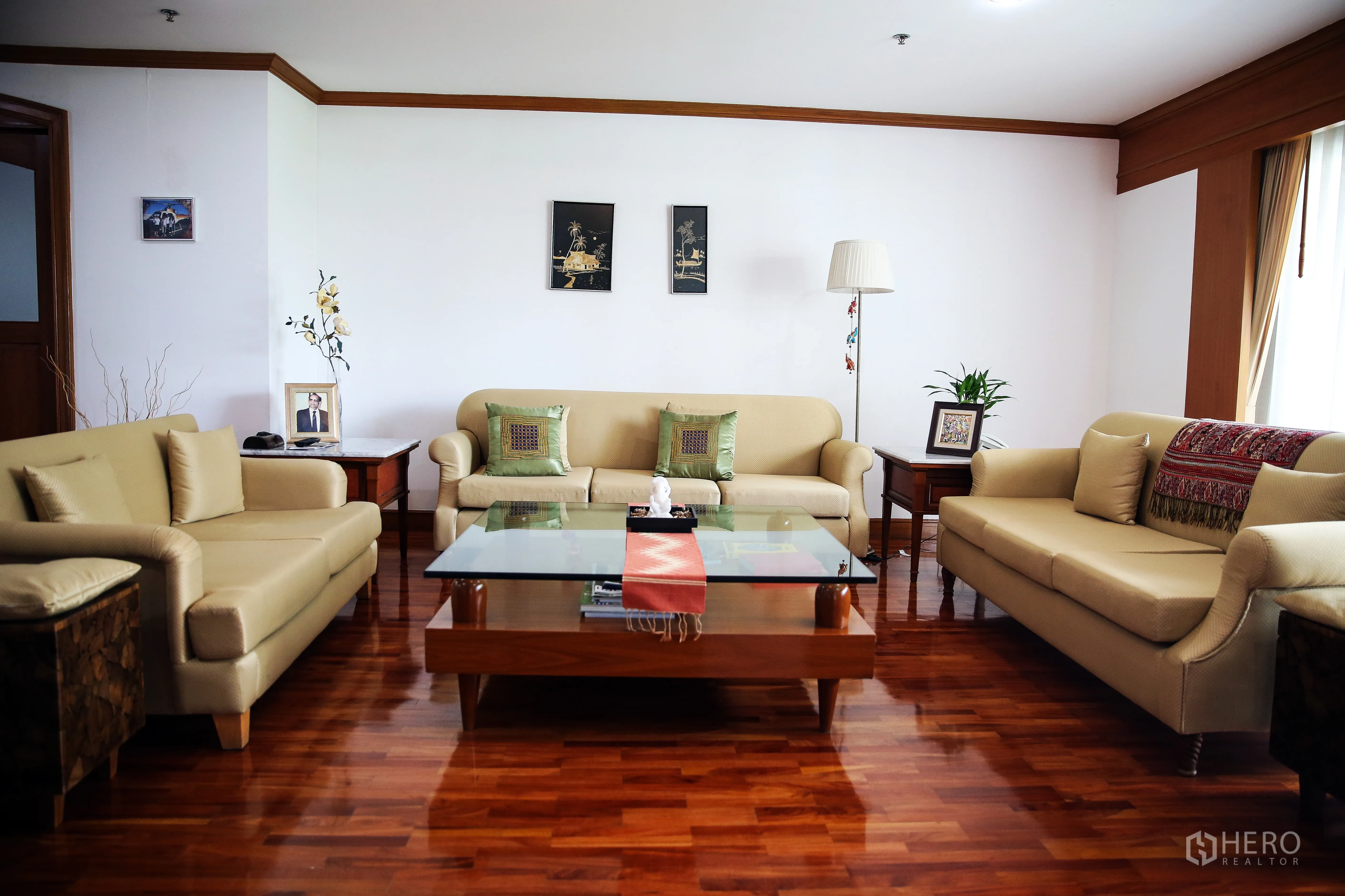 房间 出租在Khlong Toei, Bangkok - 客厅配三张米色沙发与玻璃茶几，木地板温馨大气。