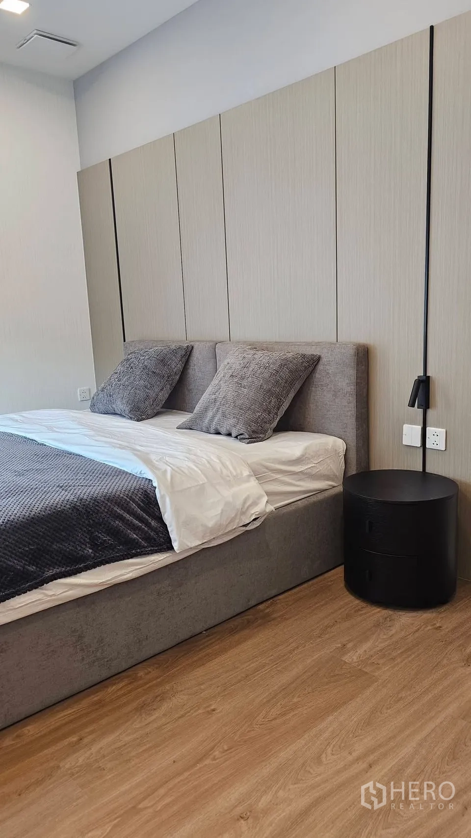 บ้านเดี่ยว for rent in Bang Phli, Samut Prakan - ห้องนอนอบอุ่นด้วยเตียงบุผ้า พื้นไม้ และโต๊ะข้างสีดำทรงกลม.