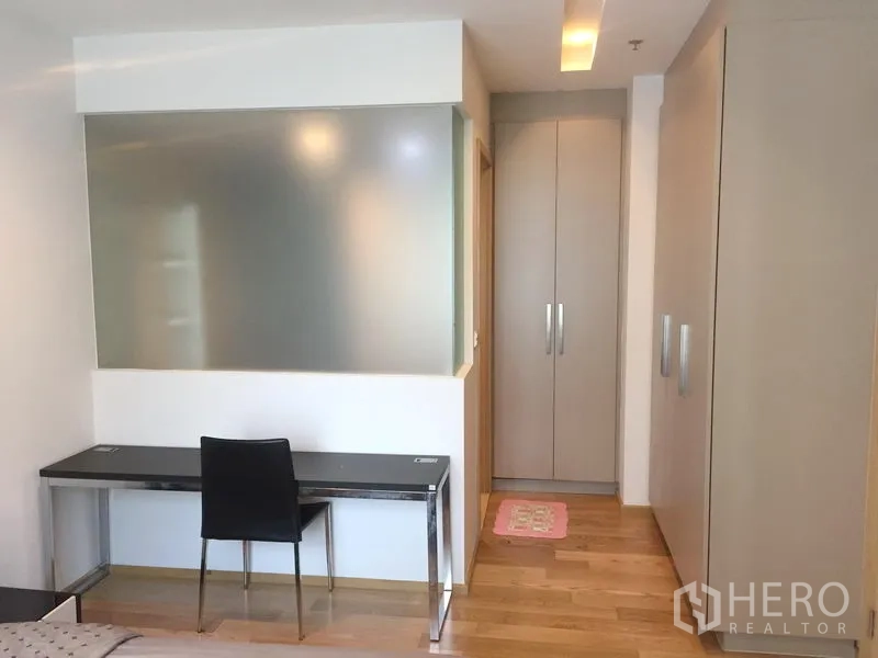 公寓 出租在Khlong Toei, Bangkok - 带书桌的学习角，旁有内置衣柜与磨砂玻璃隔断。