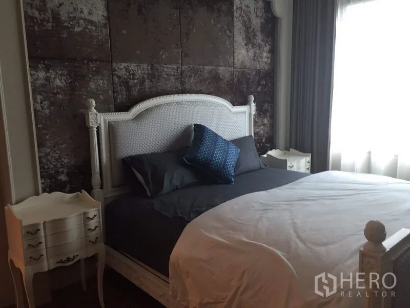 คอนโด ให้เช่าในKhlong Toei, Bangkok - ห้องนอนอบอุ่น เตียงสไตล์วินเทจ โต๊ะข้าง และหน้าต่างบานใหญ่มีผ้าม่าน