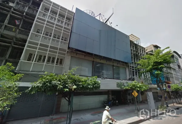Shophouse for rent in Watthana, Bangkok - Street-facing multi-storey shophouse facade with large signage panels and glass frontage along Sukhumvit near BTS Phrom Phong in Watthana, Bangkok.