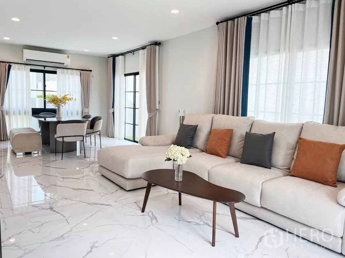 บ้าน ให้เช่าในKhan Na Yao, Bangkok - ห้องนั่งเล่นกว้าง โซฟา L-Shape โต๊ะกลาง และพื้นลายหินอ่อน ใกล้มุมทานอาหาร