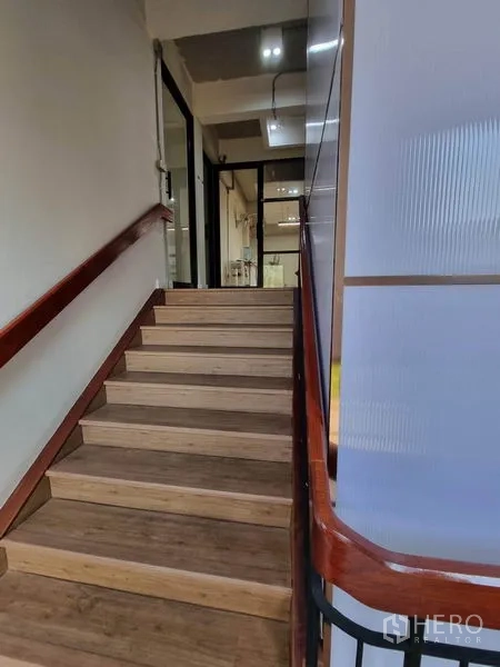 带办公室的家 出租或出售在Phaya Thai, Bangkok - 室内楼梯，木质踏步与扶手，通往办公楼层。