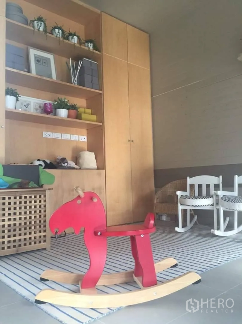 ทาวน์เฮาส์ ให้เช่าหรือขายในLat Phrao, Bangkok - ห้องครอบครัวตู้บิลท์อินไม้ พรมลายทาง และม้ากระดกสีแดง