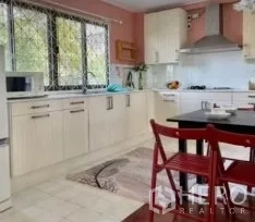 独立式住宅 出租在Phra Khanong, Bangkok - 家庭厨房，白色柜体，大窗，抽油烟机与餐桌椅。