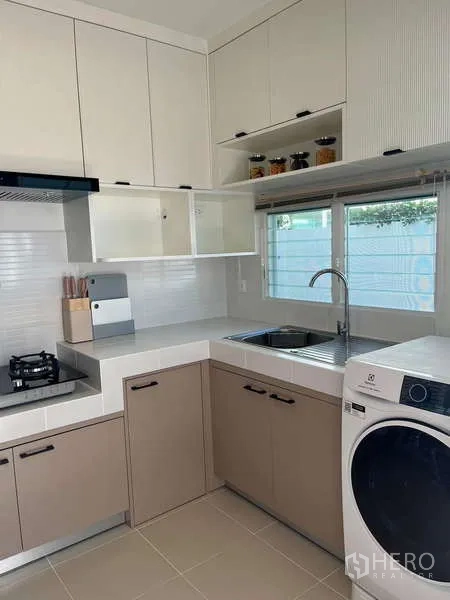 Detached House for rent in Bang Phli, Samut Prakan - Kitchen corner with sink, storage and front-loading washer.