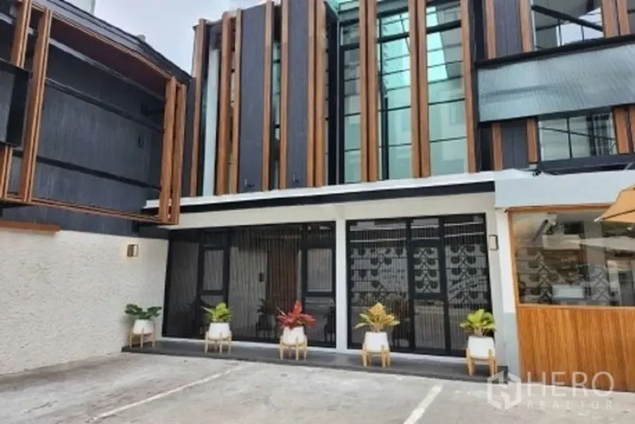 พื้นที่ขายปลีก ให้เช่าในWatthana, Bangkok - หน้าร้านติดถนน โดดเด่นด้วยแผงไม้แนวตั้งและกระถางต้นไม้