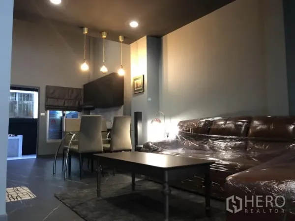 ทาวน์เฮาส์ ให้เช่าในBang Kapi, Bangkok - โซนรับแขกและรับประทานอาหารแบบโอเพ่นแพลน ไฟแขวน โซฟาขนาดใหญ่ และโต๊ะกลาง