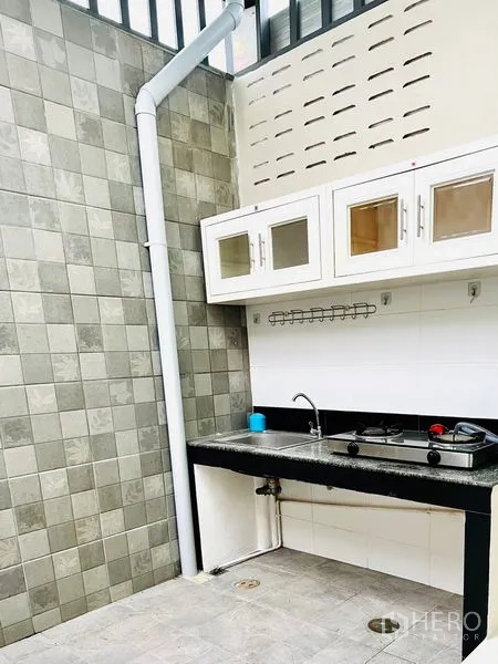 联排别墅 出租 - 半户外泰式厨房，瓷砖墙、洗槽与燃气灶，顶有采光棚。