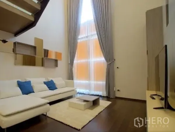 公寓 出租在Watthana, Bangkok - 明亮客厅，落地高窗与长帘引入充足自然光。