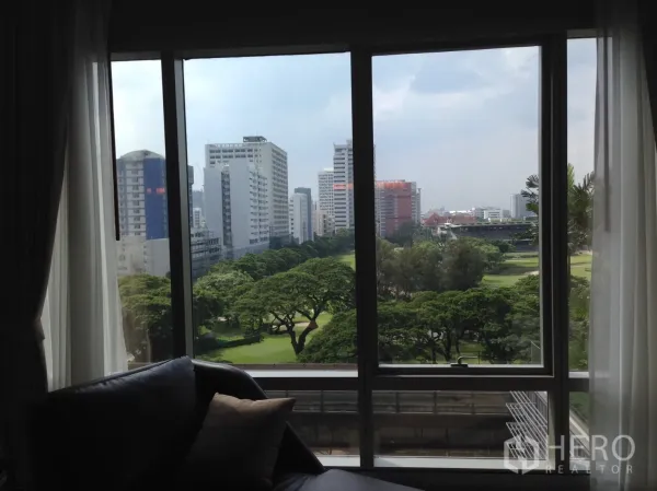 คอนโด ให้เช่าหรือขายในPathum Wan, Bangkok - วิวจากหน้าต่างห้องนั่งเล่น เห็นสวนสีเขียวและสกายไลน์กรุงเทพฯ.