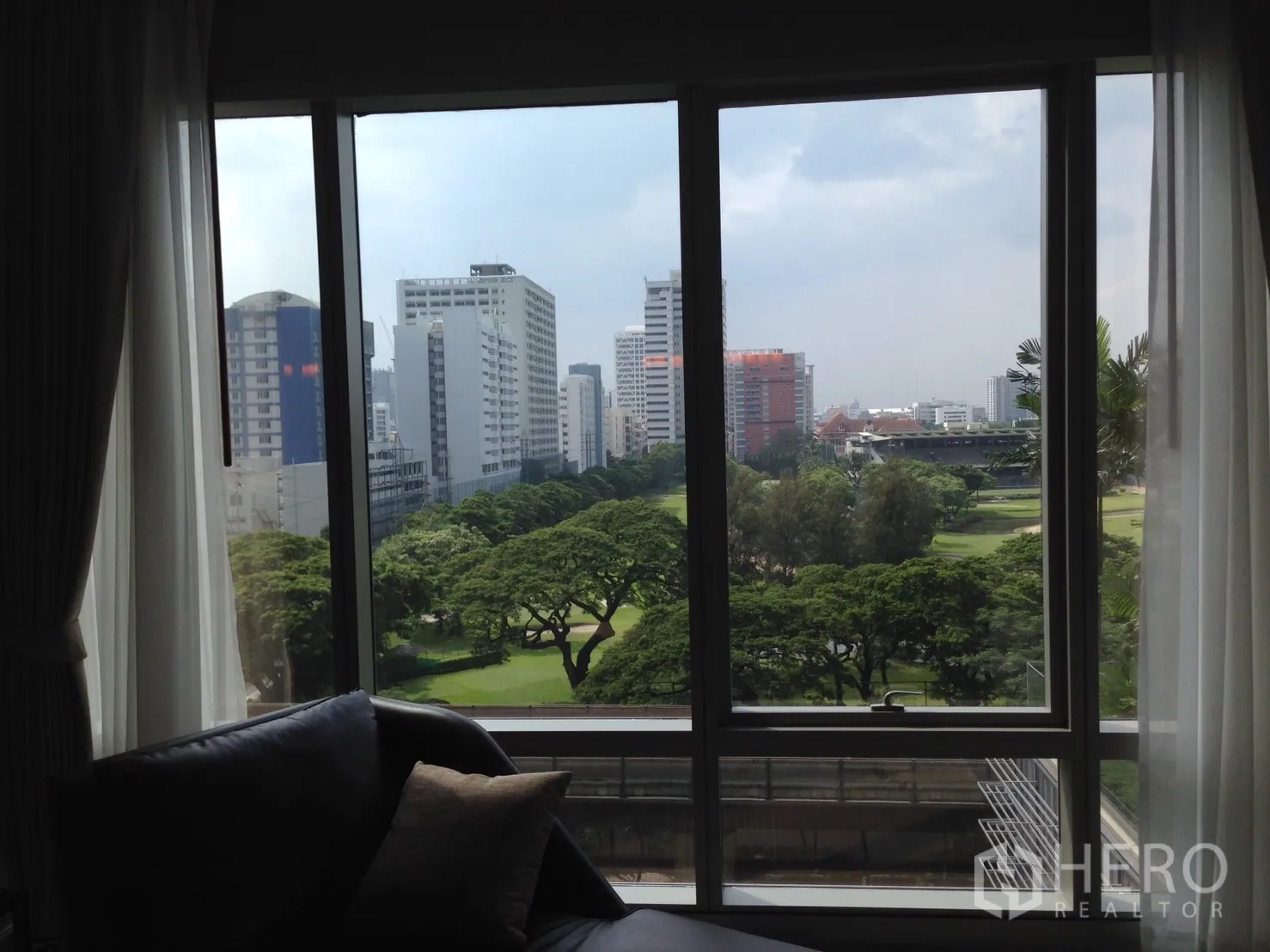 คอนโด ให้เช่าหรือขายในPathum Wan, Bangkok - วิวจากหน้าต่างห้องนั่งเล่น เห็นสวนสีเขียวและสกายไลน์กรุงเทพฯ.