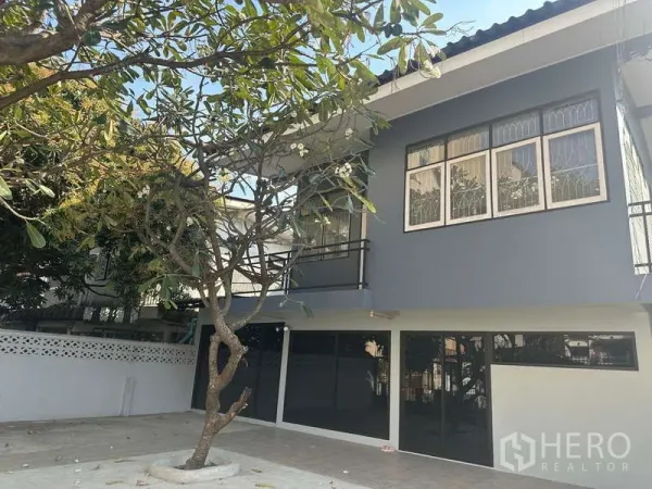 带办公室的家 出租在Din Daeng, Bangkok - 面街外观，两层家用办公楼带小阳台，前院有鸡蛋花树。