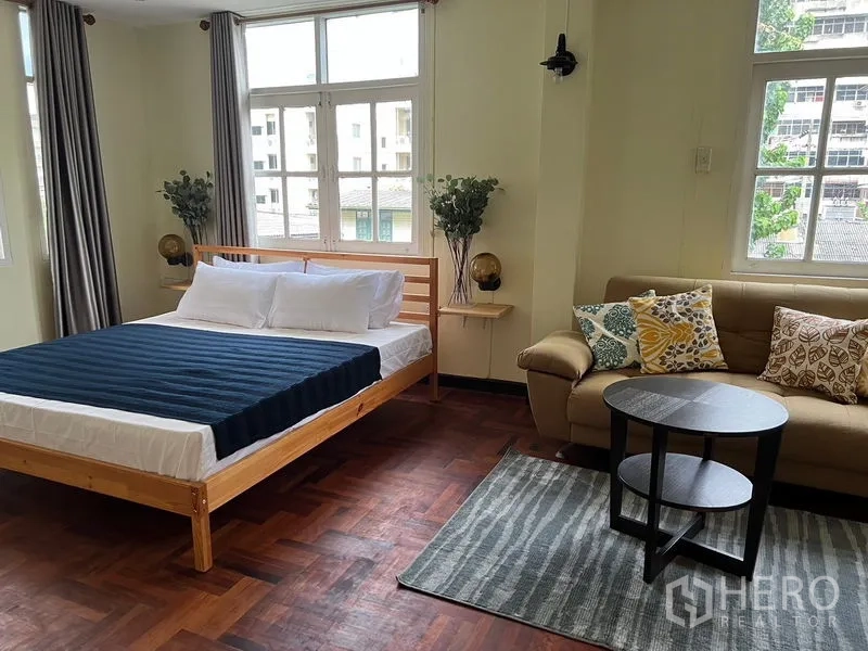 Home Office for rent in Suan Luang, Bangkok - Large studio-style bedroom with bed, sofa and round coffee table.