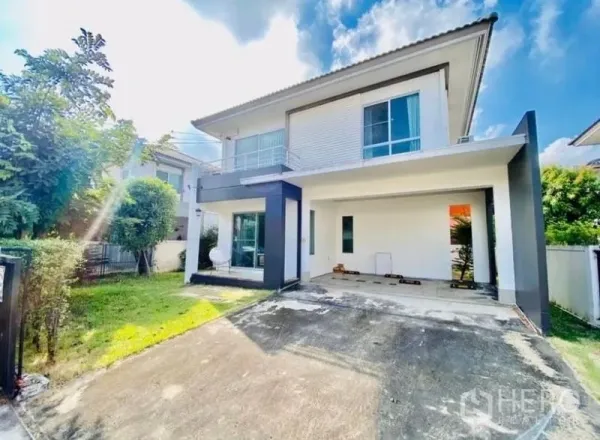 Detached House for rent or sale - Modern two‑storey detached house exterior with balcony, covered carport and front lawn under blue sky in Bang Phli.