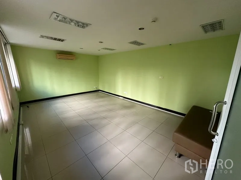 สำนักงาน ขาย - ห้องสำนักงานโล่ง ผนังสีเขียว พื้นกระเบื้อง และแอร์ติดผนัง