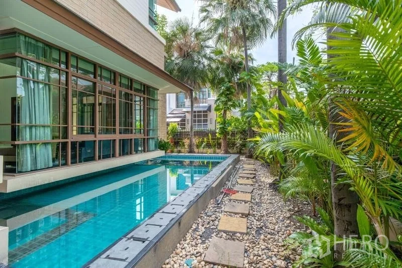 บ้าน ให้เช่าในWatthana, Bangkok - สระว่ายน้ำส่วนตัวข้างบ้าน ล้อมด้วยสวนทรอปิคอลและทางเดินโรยหิน.