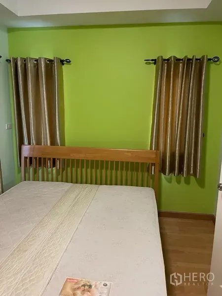 ทาวน์เฮาส์ ให้เช่าในKhlong Toei, Bangkok - ห้องนอนอบอุ่น ผนังสีเขียว เตียงไม้ และหน้าต่างสองบาน