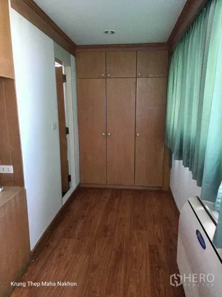 คอนโด ให้เช่าในWatthana, Bangkok - มุมห้องนอนมีตู้เสื้อผ้าบิวท์อิน พื้นไม้ และผ้าม่านสีเขียว