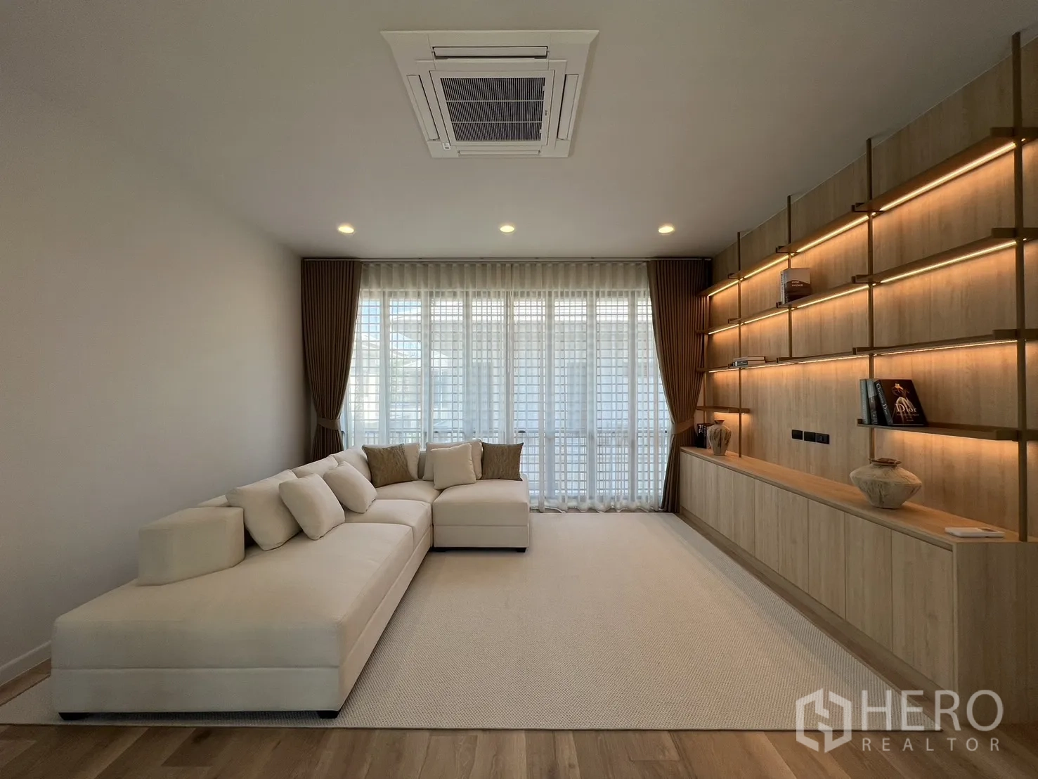 Detached House for rent or sale in Bang Kapi, Bangkok - Family lounge facing balcony with floor-to-ceiling windows and privacy screens.