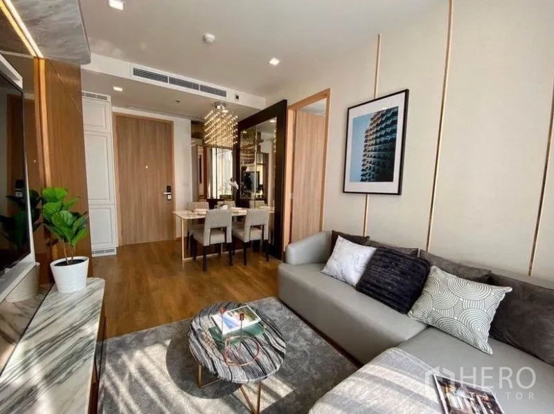 คอนโด ให้เช่าในWatthana, Bangkok - ห้องนั่งเล่นสว่างของคอนโดในเขตวัฒนา โซฟาสีเทา โต๊ะกลางหินอ่อน มองเห็นมุมทานอาหารและโคมไฟระย้า