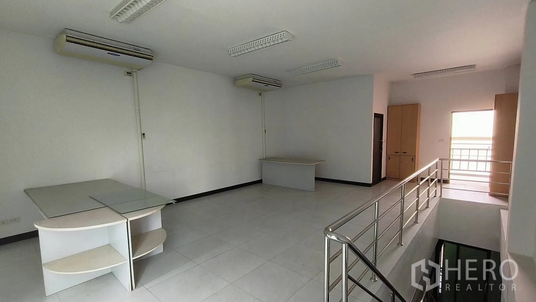 Office Space for rent in Khlong Toei, Bangkok - Upper mezzanine workspace with air conditioners and safety railing.
