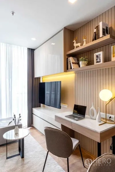 Condominium for rent in Watthana, Bangkok - Study nook with floating desk, open shelves and TV unit by a floor-to-ceiling window.
