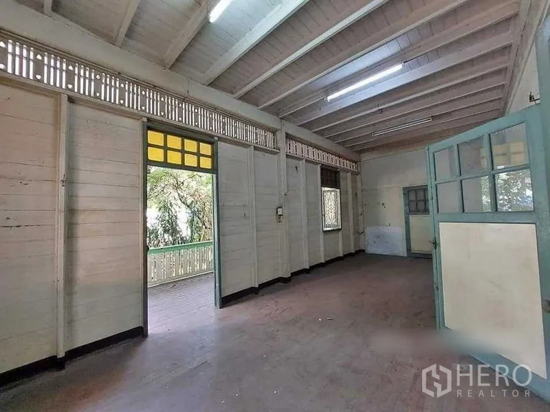 Detached House for rent in Bang Rak, Bangkok - Room with beamed ceiling opening to a balcony, allowing natural light inside.